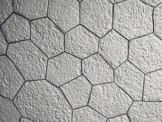Interesting pattern of hexagonal shaped white bricks on the wall or floor, made of rock stone and a...