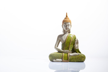 Green and golden Buddha statue, on white background. .Meditation, spirituality and zen concept.