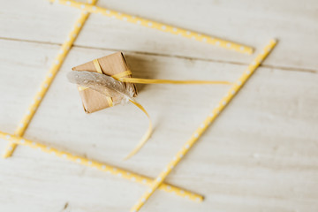 Kommunion, Konfirmation, Firmung, Taufe - Feder auf Geschenk aus Natur Papier mit gelbem...