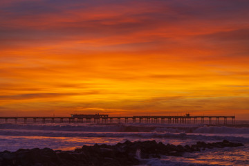 Fototapeta na wymiar Nice colorful clouds after sunset at a pier over the Pacific Ocean. Ocean Beach neighborhood of San Diego, California.
