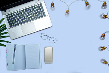 flat lay of laptop and notebook on light blue background