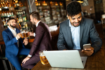 Handsome young business man, blogger or remote working with laptop in bar