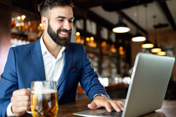 Handsome business man using laptop at his work break in restaurant