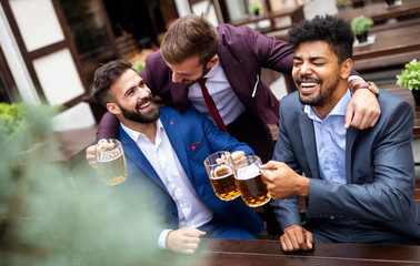 People, men, leisure, friendship and celebration concept. Happy male friends drinking beer at pub