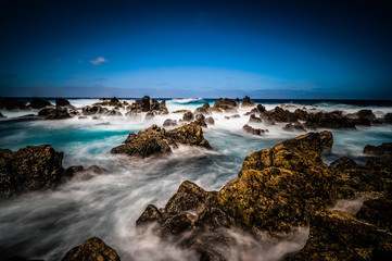 Fototapeta na wymiar Porto Moniz - Long exposure of rocks and waves at vulcanic coast - beautiful landscape scenery of Madeira Island, Portugal