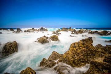 Fototapeta na wymiar Porto Moniz - Long exposure of rocks and waves at vulcanic coast - beautiful landscape scenery of Madeira Island, Portugal