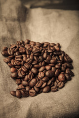 Composition with a coffee beans on a linen napkin for background. Toned