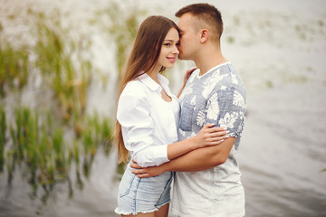 Cute couple walking near water. Girl in a white shirt. Pair by the river
