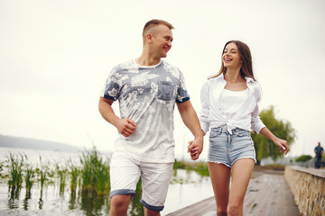 Cute couple walking near water. Girl in a white shirt. Pair by the river