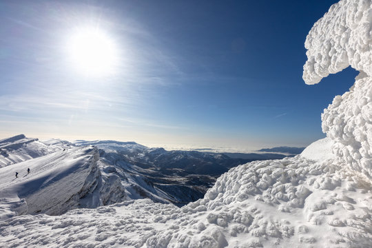 paisaje invernal con montañeros andando sobre la nieve