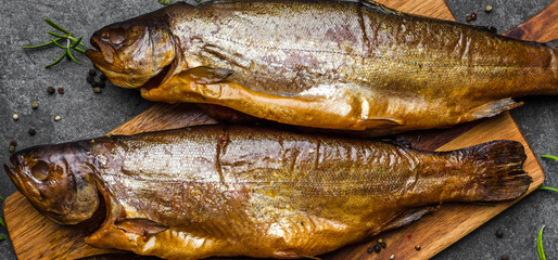 Smoked fish with spices on dark background