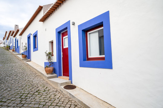 Cobblestone street with blue and white traditional colorful homes and buildings in the Algarve town of Odeceixe