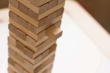 Tower of wooden blocks. Board game jenga. The concept of education, risk, development and growth. Place for the test. Games for children and parents.