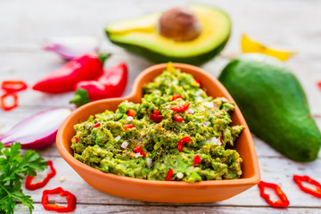Delicious guacamole in a heart-shaped bowl.