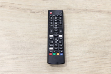 TV remote control on wooden table.