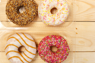 Four glazed doughnuts in plastic packaging