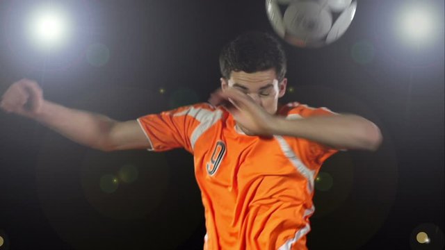 Man heads a soccer ball / football on a Black Background. Header. Super Slow motion