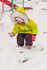 Fototapeta na wymiar little child on winter walk touches the snow