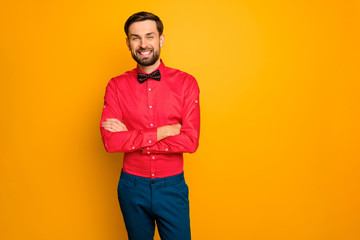 Photo of attractive macho business guy arms crossed friendly person reliable worker wear stylish red shirt with black bow tie blue trousers isolated yellow color background