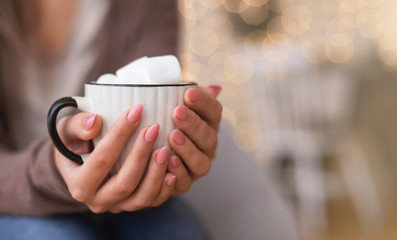 Cup of hot chocolate with marshmallows in female hands