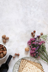 Pesah celebration concept (Jewish passover holiday) design with wine, matzo, flowers, and nuts on...