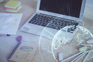 Computer on desktop with social network hologram. Multi exposure. Concept of international people connections.