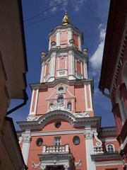 Pink stone tower with white trim on a blue sky background