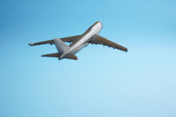 Travel concept an airborne airplane on blue background mimic flying on clear blue skies