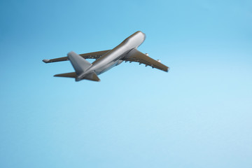 Travel concept an airborne airplane on blue background mimic flying on clear blue skies