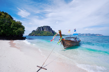 Beautiful landscape with traditional longtail boats, rocks, cliffs, tropical white sand beach....