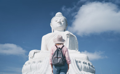 Traveling by Thailand. Pretty young woman walking in the Big Buddha Temple, famous Phuket sightseeing.