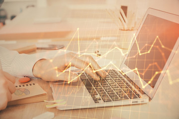 Double exposure of stock market graph with man working on laptop on background. Concept of financial analysis.