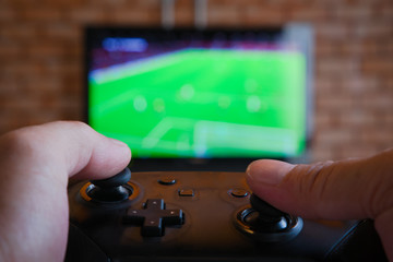 Bangkok, Thailand - January 22, 2020: Photo of playing  FIFA online football video game from Nintendo Switch console. Close-up shot of fingers throwing joystick in home. Indoor entertainment. © tigercat_lpg