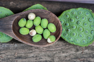 Lotus seed or lotus nut. The traditional Chinese and Indian medicine. Good for healty and can eat both fresh and dried seed as a snack or cooking as a food. Shooting on vintage wood surface table.