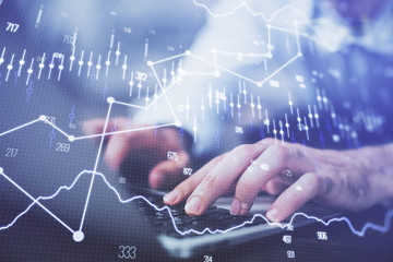 Forex graph with businessman typing on computer in office on background. Concept of analysis. Double exposure.