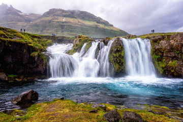 Fototapeta na wymiar Famous Kirkjufellsfoss waterfall, favorite tourist destination in Iceland. Amazing dramatic landscape, harsh scandinavian nature, outdoor travel background