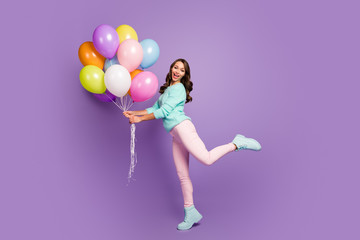 Full body photo of cheerful feminine girl hold many baloons enjoy festive woman day event scream wear turquoise pastel sweater pink footwear isolated over purple color background