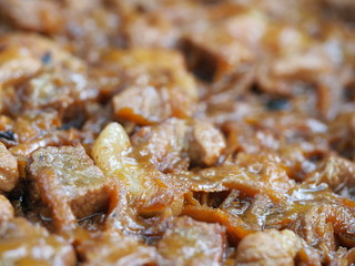 Beef goulash with vegetables and spoon, close up. Stewed meat in a frying pan.