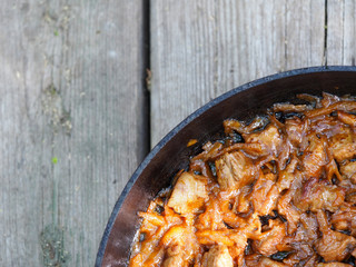 Beef goulash with vegetables and spoon, close up. Stewed meat in a frying pan.