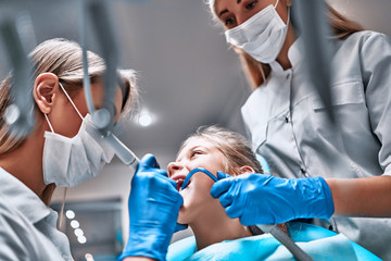 Professional dentist working with little patient in modern clinic