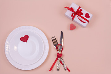 Valentine's day table setting on a light pink background with copy space