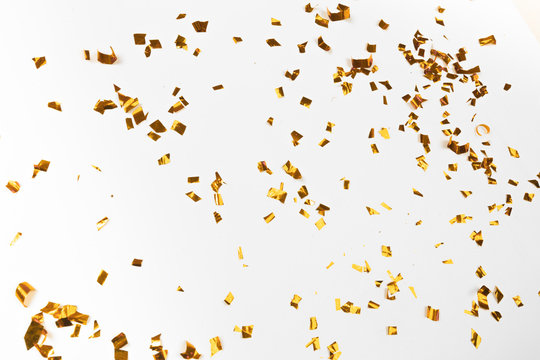 Golden flying sparkles on white   holiday background. Festive backdrop for your projects.- Image