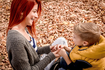 Happy mother and her small son enjoying in autumn day.