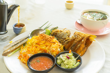 Biryani rice on white plate ,Indian dish made with highly seasoned rice and fish,vegetables.
