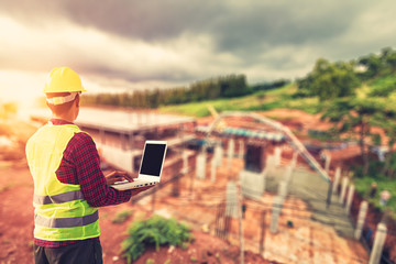 Construction Worker Planning use laptop for working and checking site construction on mountain.