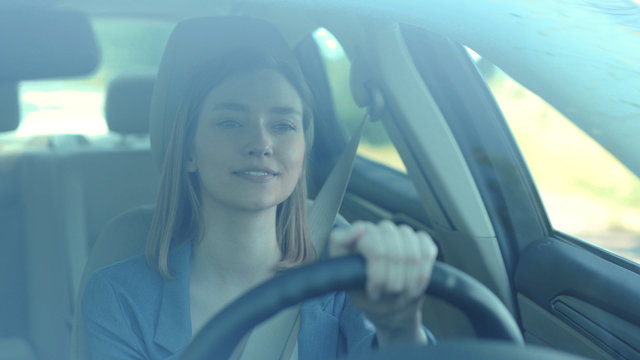 Happy young woman driving car smile look around sing dance through big sunny face automobile road travel attractive emotional enjoyment freedom holiday moving outdoors slow motion