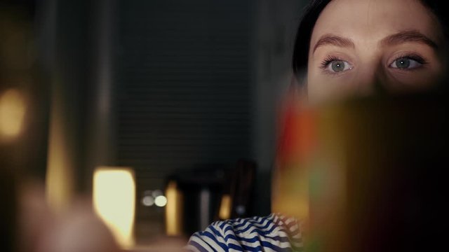 Hungry girl at night searches for food in refrigerator and finds apple. Diet, proper nutrition, fasting, healthy lifestyle, pregnancy, raw food diet, gluttony concept. Slow motion and close up