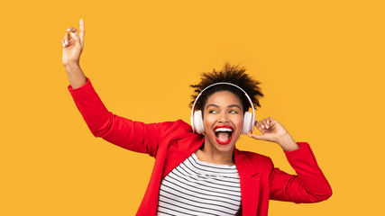 Portrait of excited black girl enjoying music at studio