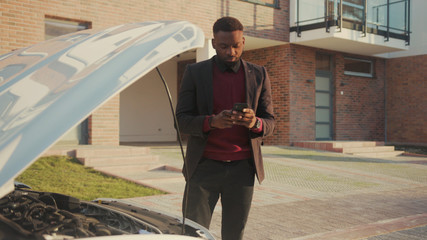 Face african american man stand near broke car calling for help by phone emergency engine problem...