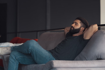 Fototapeta premium Young man sitting relaxing on the couch